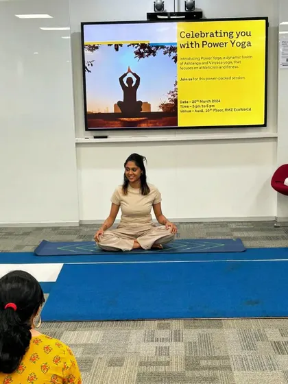 Seated in Sukhasana (Easy Pose) before starting a Power Yoga session, demonstrating the calm and focus that precedes an energetic practice.