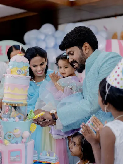 The family gathers to cut the spectacular carousel cake at the Candyland-themed birthday party.