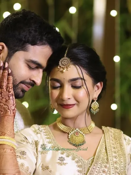 For this couple's ring exchange ceremony, I created a timeless and romantic look. The focus was on luminous skin, a classic red lip, and beautifully defined eyes that complemented her intricate henna and stunning white and gold lehenga.