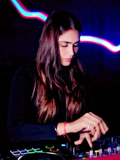 Mixing tracks with a cool blue neon light in the background. This photo has a futuristic, moody vibe that reflects the tech and deep house elements in my sets.