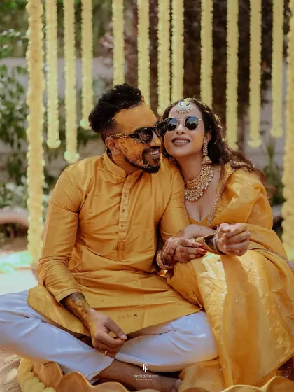 A cool and happy couple posing in sunglasses during their Haldi ceremony. This photo shows their fun-loving personalities and the relaxed vibe of the celebration.