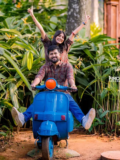 An exuberant and joyful shot of a couple on a scooter. The bride's happy expression and the groom's smile make this a wonderfully candid and fun photo.