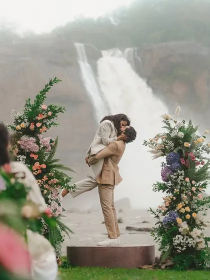 A joyful, triumphant moment as the groom lifts his bride against the epic backdrop of the falls. This shot is the pinnacle of celebration, a perfect blend of love and magnificent scenery.