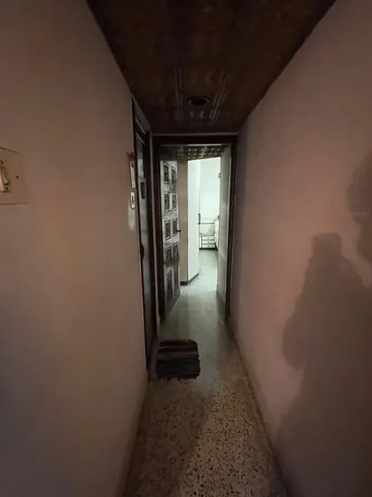 **BEFORE:** A narrow, dark corridor with a heavy, carved wooden door, which closed off the living spaces and blocked natural light.