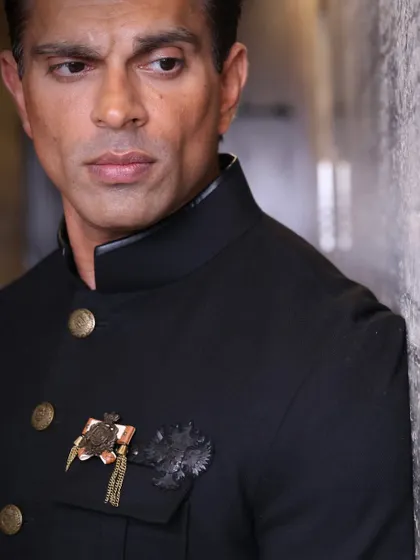 A close-up shot focusing on the details of the Shantanu & Nikhil ensemble and Karan Singh Grover's intense gaze.