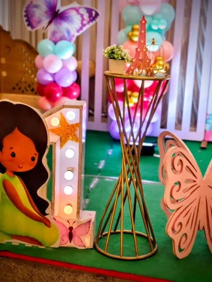 A close-up of the decor detail's, including a light-up number '1', a fairy cutout, and a miniature Eiffel Tower prop.