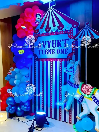 A carnival-themed photo booth with a carousel horse prop and a light-up number "1," perfect for capturing first birthday memories.