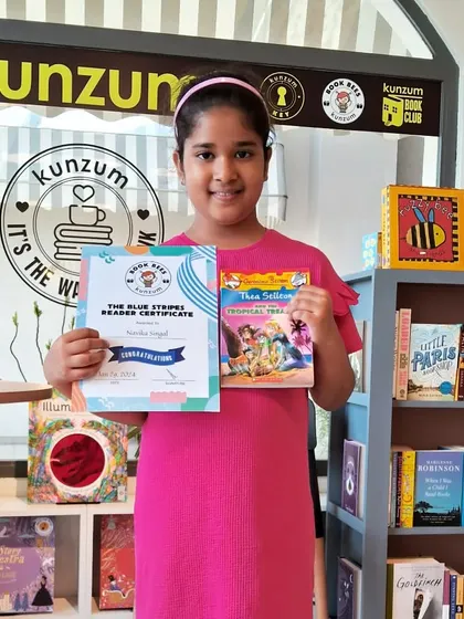 Another proud Blue Stripes reader. This young member has successfully completed her reading goal and is holding her certificate of achievement and a new book to start her next adventure.
