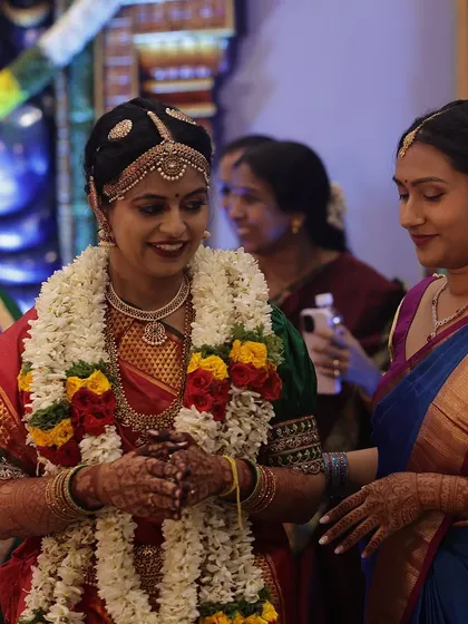 A happy bride during her wedding, her hands adorned with a deep and beautiful mehendi stain.