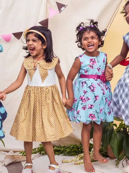 A group of friends having fun in their favorite dresses. This shot captures the joy and energy of childhood, with each girl showing off her unique style.