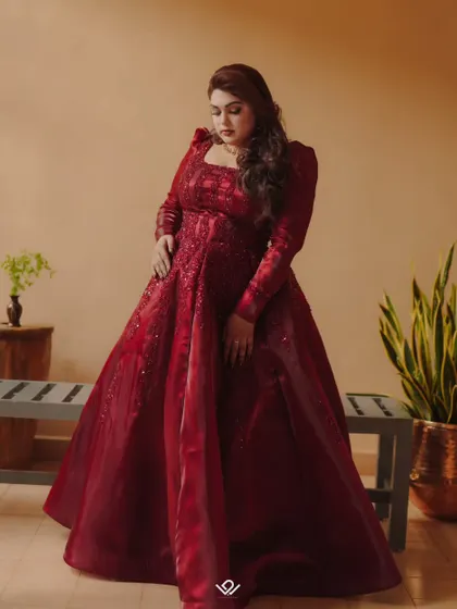 A full-length portrait of a bride in a magnificent red ball gown, showcasing a modern reception look.