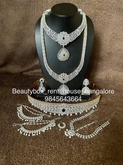 A complete Victorian-style bridal set with a white diamond finish. This rental includes a choker, long necklace, vaddanam, and hand accessories.
