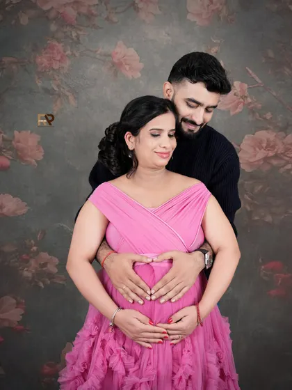 The classic heart-hands pose. The couple's hands form a heart on the baby bump, a timeless symbol of their love for their growing family.