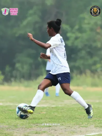 A player in our white kit dribbles the ball with precision and focus, looking for an opening in the opponent's defense.