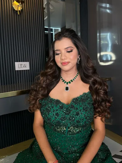 A serene moment captured, highlighting the beauty of the off-shoulder gown and the statement necklace.