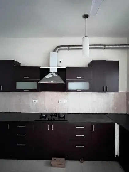 Before: A standard builder-grade kitchen in the 'Cover me in Sunshine' home, with dark cabinets and a dated layout.