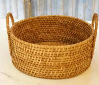 A round, tightly woven basket with integrated handles, showcasing beautiful craftsmanship. This versatile piece can be used as a serving tray, a decorative bowl for your coffee table, or for organizing small items.