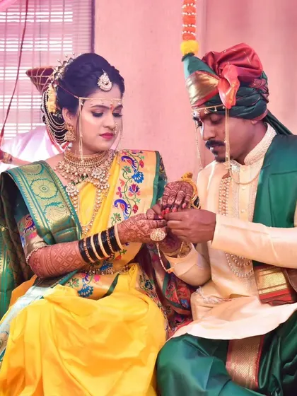 The bride and groom during a key wedding ritual, their hands joined in a moment of quiet connection and tradition.