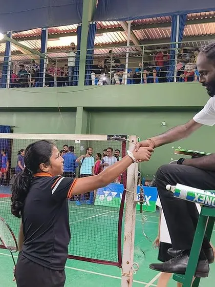 Sportsmanship is a core value. A player shakes hands with the umpire after a hard-fought match.