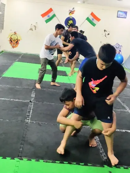 Our kids' summer camp focuses on practical skills. Here, students practice wrestling takedowns, learning how to control an opponent's posture and bring the fight to the ground safely.
