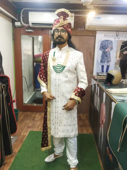 We design complete, head-to-toe groom ensembles. This client is ready for his wedding day in a custom white sherwani, complemented by a matching pagri (turban), a contrasting maroon dupatta, and traditional jewelry for a cohesive, royal look.