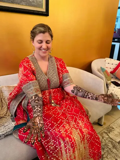 This bride looks stunning in her red outfit, her detailed portrait mehndi on full display.