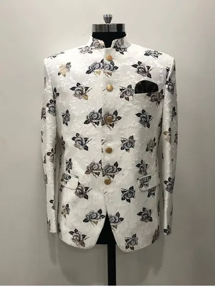 A white Jodhpuri jacket with a sophisticated grey and black floral print, shown on a mannequin. This is a great option for a day event or a sangeet ceremony.