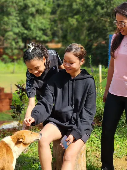 A similar candid photo showing the gentle interaction between our trekkers and a friendly dog.