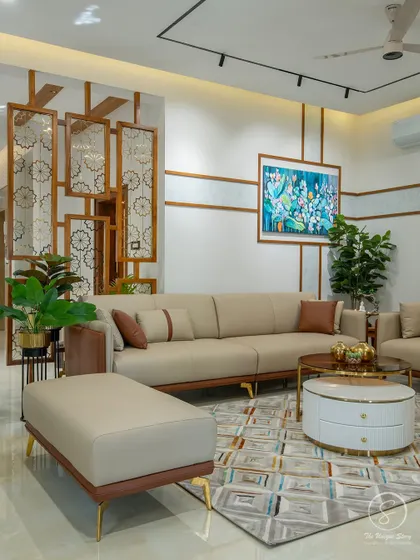 The living room is furnished with elegant beige and brown leatherette sofas, complemented by a vibrant piece of abstract art. The geometric-patterned rug and decorative partition add layers of texture and visual interest.