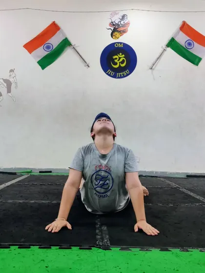 A student performing Bhujangasana, or cobra pose. This is a great exercise for strengthening the spine and improving posture.