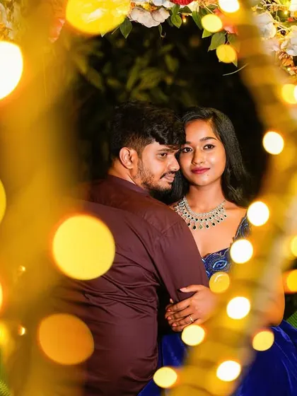A creative shot using the warm glow of fairy lights to frame a romantic couple's portrait.