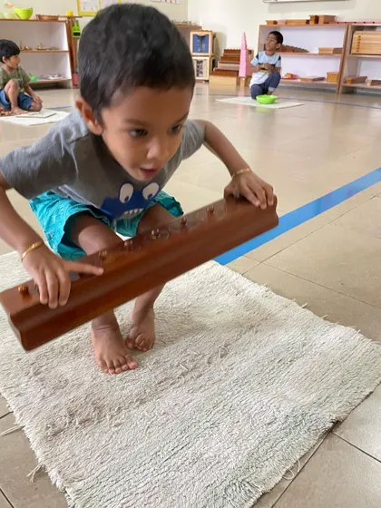 The Cylinder Blocks are a foundational sensorial material. By fitting each cylinder into its correct socket, the child refines their pincer grip for writing and develops their ability to visually discriminate between different dimensions.