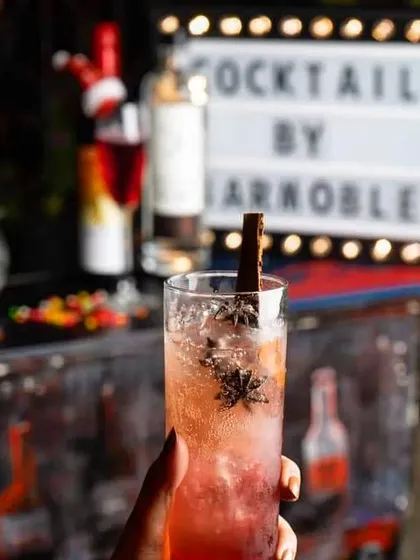 A spiced winter cocktail garnished with a cinnamon stick and star anise. We create seasonal menus to match the mood, from warm winter spices to refreshing summer fruits.