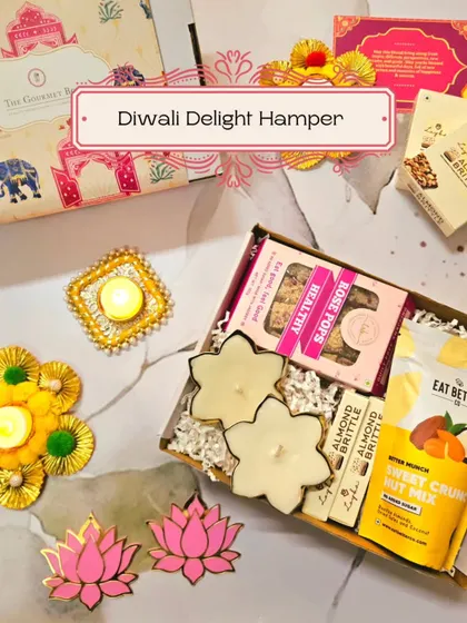 An inviting image of the Diwali Delight Hamper, showing the combination of sweet crunchy nut mix, rose pops, and almond brittle with festive diyas.