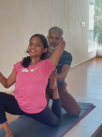 A smile of achievement. With a little support, this student finds more depth and comfort in her backbend. My role as a teacher is to help you explore your limits safely and joyfully, fostering a positive relationship with your practice.