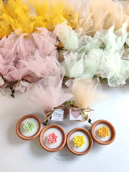 A large corporate order of 130 succulent clay pot candles for a Women's Day celebration, showcasing a variety of pastel colors.