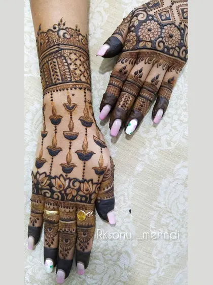 A playful and festive design featuring hanging diya lamps on one hand and a beautiful floral and geometric pattern on the other. This is a great choice for Diwali or other celebrations.