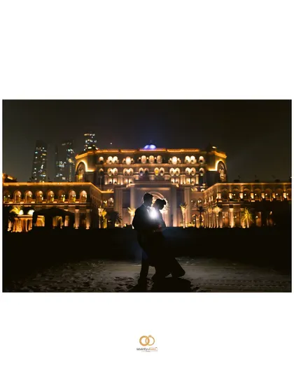 A stunning silhouette against the illuminated Emirates Palace at night. This dramatic, backlit shot is the definition of an epic and glamorous pre-wedding portrait.