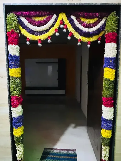 A vibrant and colorful floral decoration for a home entrance. The mix of flowers creates a joyful and welcoming look.