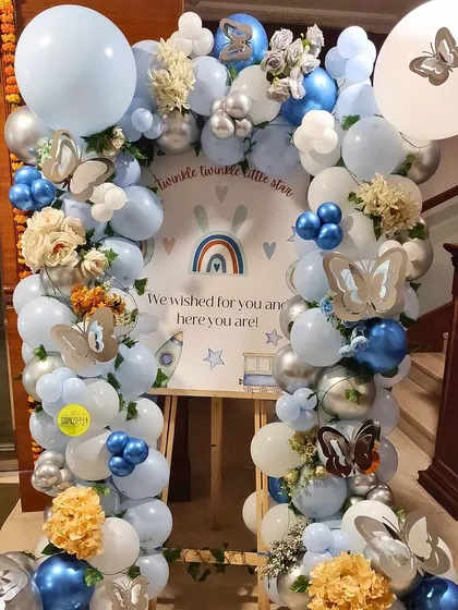 A beautiful "Twinkle Twinkle Little Star" themed baby welcome. The easel board is framed by a stunning balloon arch in shades of blue, silver, and white, with delicate butterfly accents.