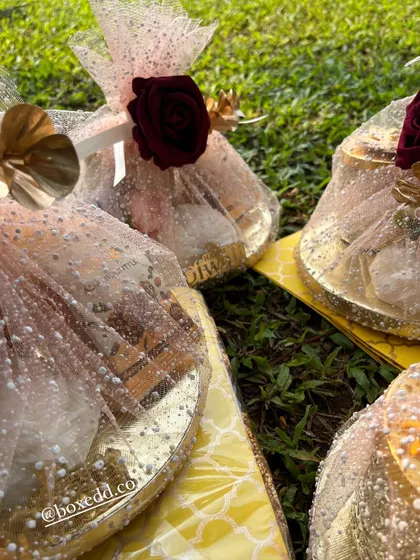 A close-up of our festive gift platters. The combination of the gold platter, sparkling wrap, and rich floral accents creates a look of pure opulence.