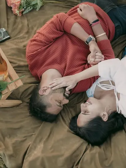 An overhead shot of a couple sharing a moment during their picnic-themed pre-wedding shoot. This angle provides a unique and intimate perspective.
