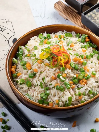 This bowl of fried rice is shot to look like a hearty, satisfying meal. The composition includes the restaurant's branding, making it a great asset for their specific marketing needs.