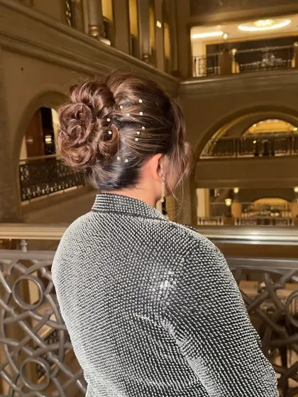 An intricate, twisted texture bun adorned with delicate rhinestones. This hairstyle is perfect for an evening event that calls for understated opulence.