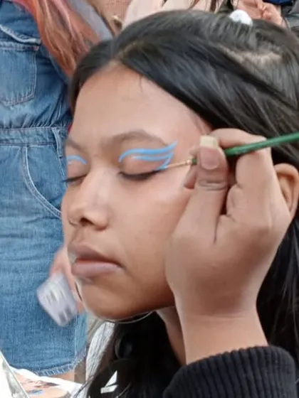Creating a bold graphic eyeliner look with bright blue paint. This is a great alternative to traditional makeup.
