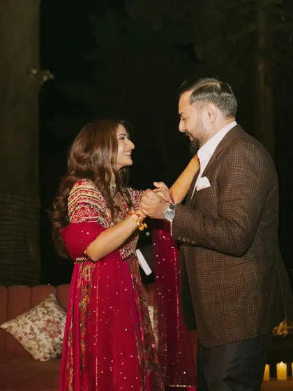 A candid moment of the couple dancing. Her flowing red anarkali is perfect for an evening of celebration.