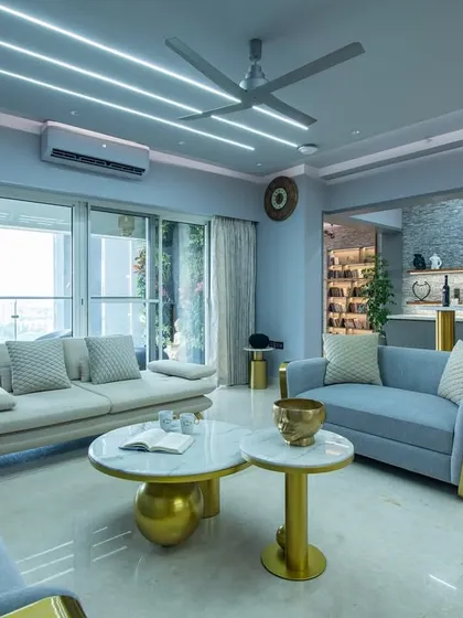 This angle focuses on the main seating area, with plush sofas and marble-topped coffee tables. The geometric LED lighting on the ceiling adds a modern, dynamic touch to the classic wall paneling.