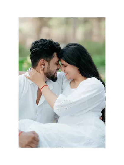 A framed, close-up shot of a couple touching foreheads and smiling. The white border gives this intimate forest portrait a clean and modern presentation.