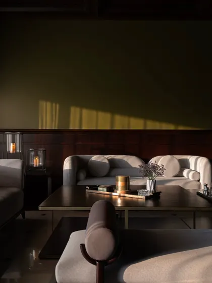 A close-up detail of the seating area, focusing on the soft textures of the sofa and the warm, indirect lighting. It’s these small details that make a house feel like a comfortable, luxurious home.