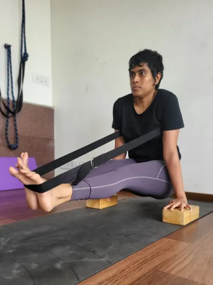 Combining blocks and straps, this student works on the foundational strength for Brahmacharyasana. This setup allows her to focus on core engagement and arm stability, building a solid base for the full posture.